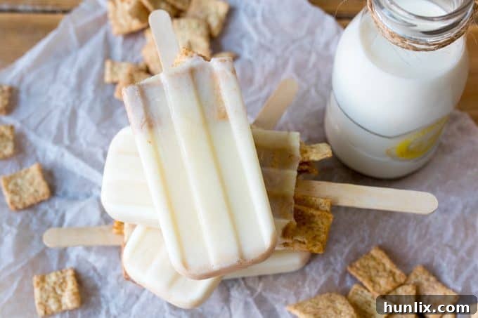 A stack of golden brown cereal milk popsicles on a white surface, invitingly cool and creamy.