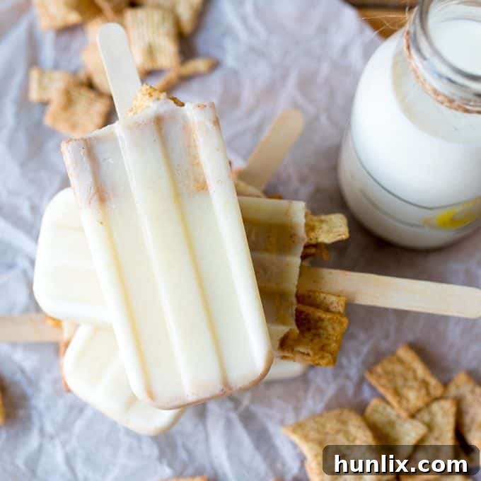 Close-up shot of a stack of creamy cereal milk popsicles with visible cereal bits, ready to be enjoyed.