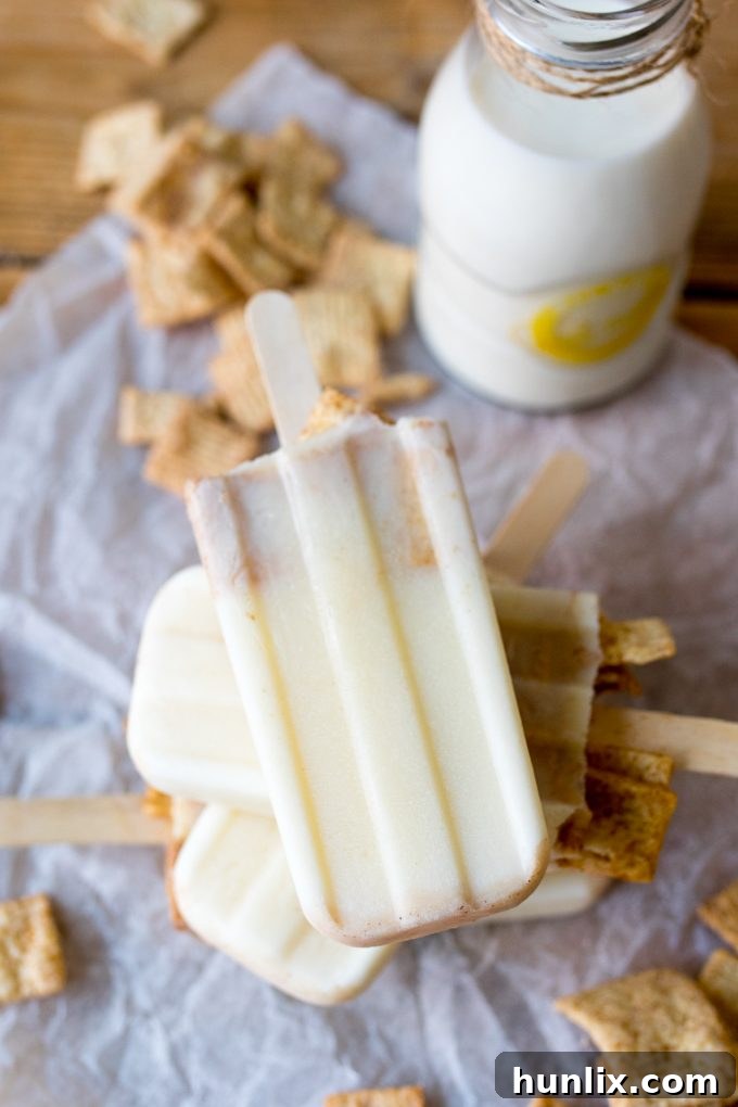 A trio of delicious cereal milk popsicles, showcasing their creamy texture and inviting golden hue, standing upright.