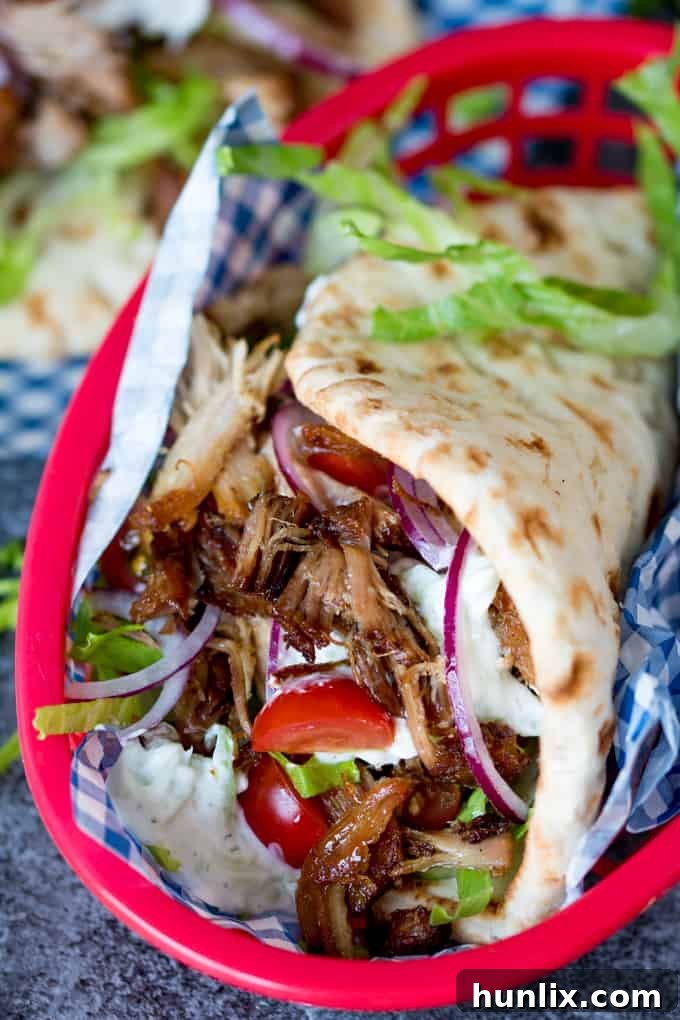 A hearty and flavorful serving of homemade pork gyros, complete with fresh toppings and sauces, presented for enjoyment.