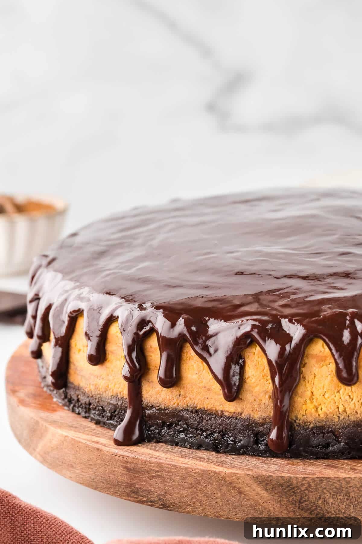 Decadent Chocolate Pumpkin Cheesecake on a rustic wooden platter, ready to be served.