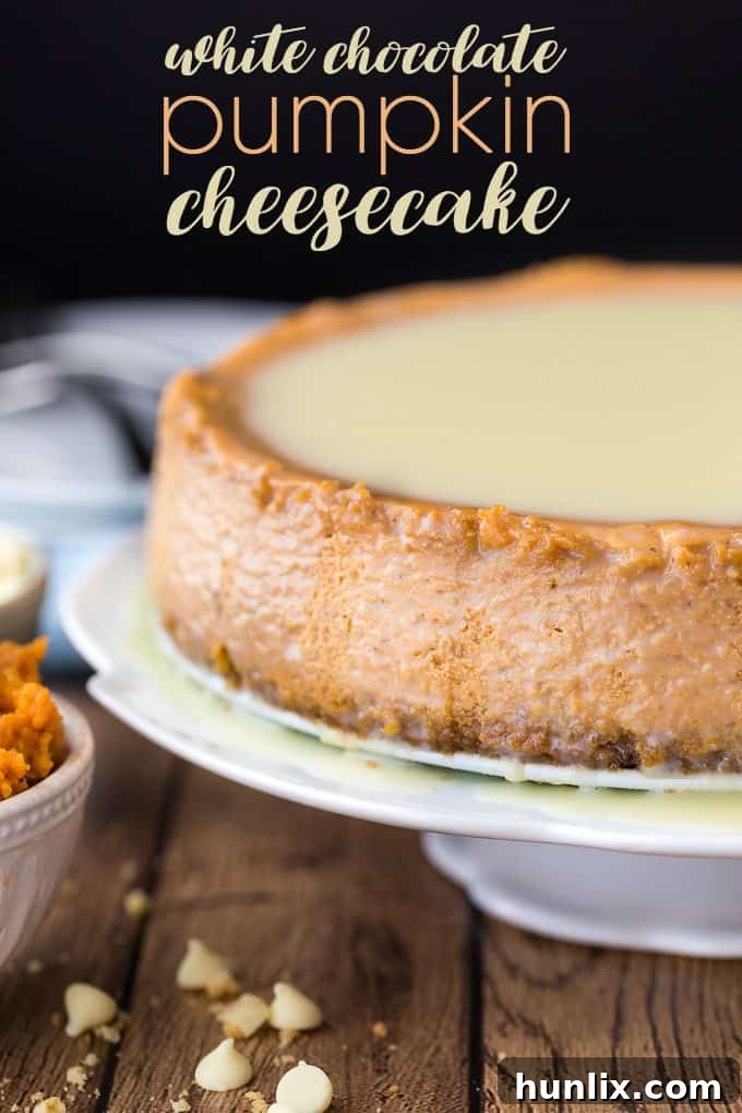 A top-down view of the whole white chocolate pumpkin cheesecake, decorated with a smooth glaze and a festive sprinkle, ready for slicing.