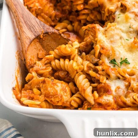 Baked Chicken with Tarragon Pasta 11 Baked chicken and tarragon pasta in a casserole dish with a wooden spoon.
