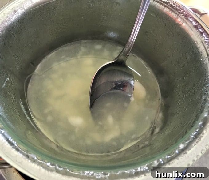 Crafting Layered Jar Candles 5 Stirring melting soy wax to ensure even consistency.