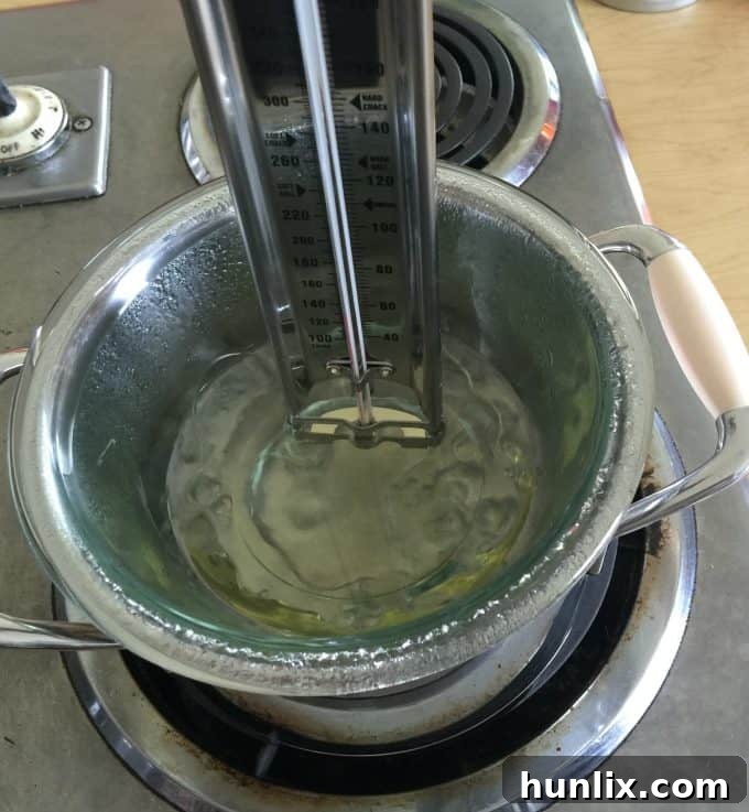 Crafting Layered Jar Candles 6 Checking wax temperature with a thermometer for candle making.