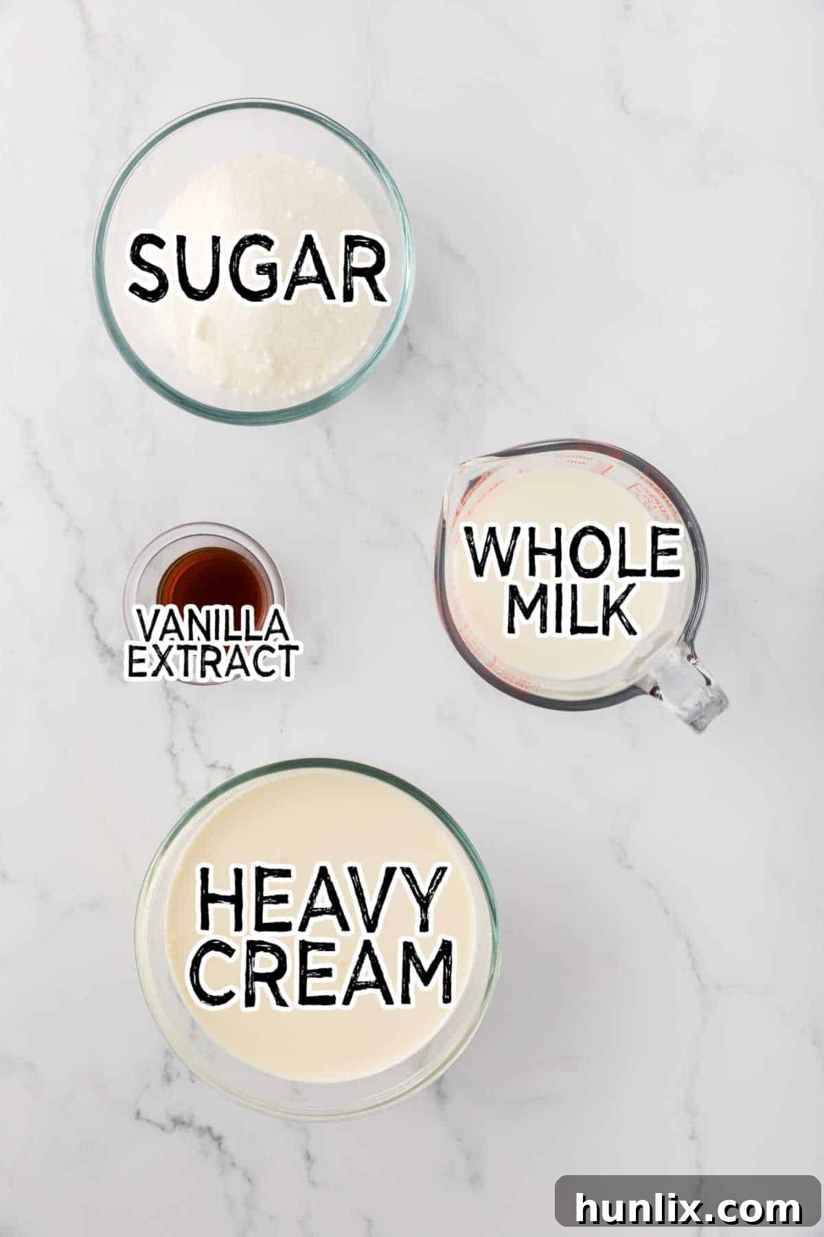 Ingredients laid out on a table to make homemade vanilla ice cream: milk, cream, sugar, and vanilla extract.