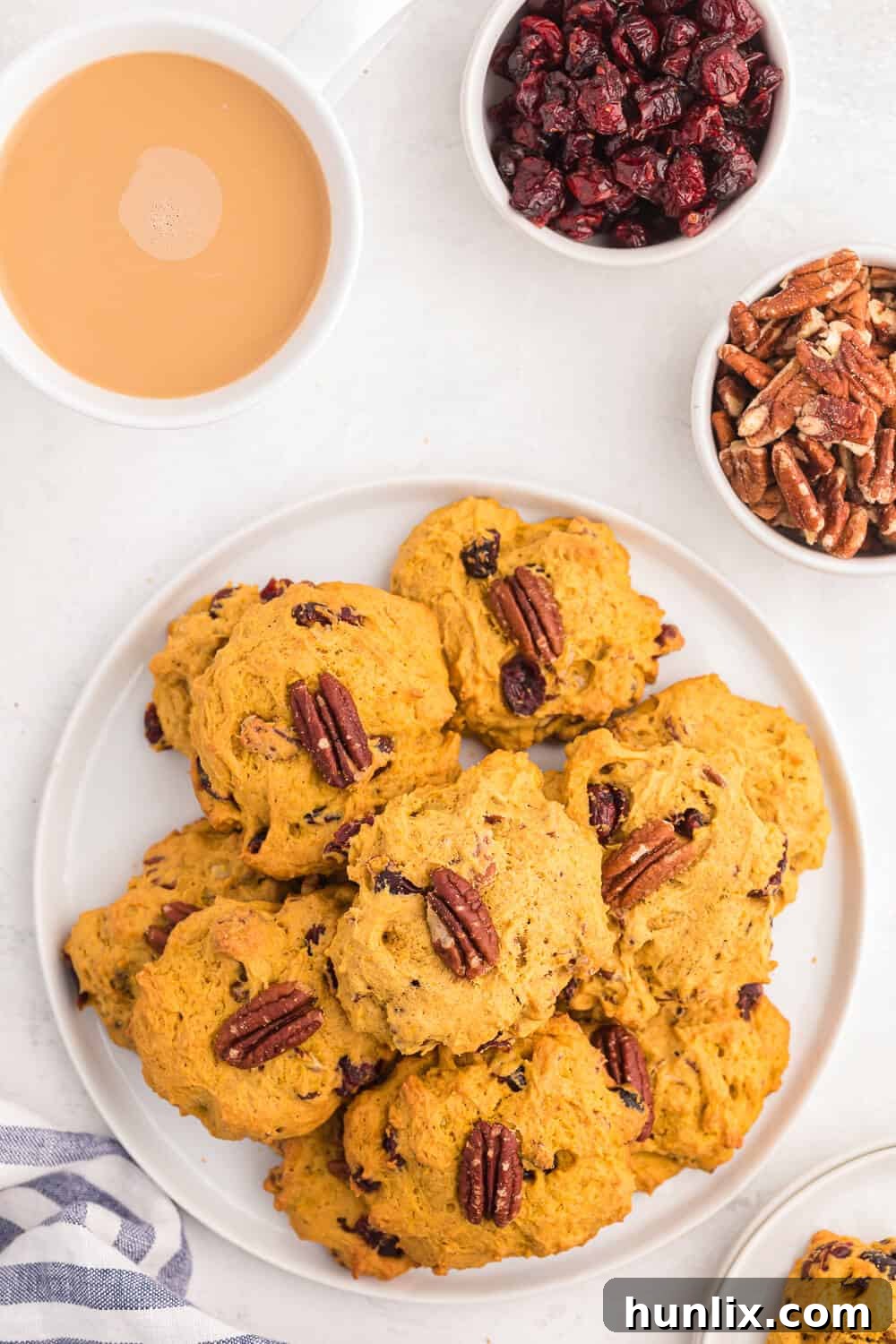 A beautifully arranged plate of freshly baked pumpkin breakfast cookies, garnished with whole pecan halves.