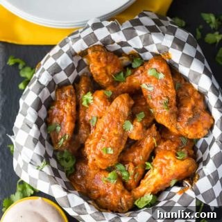 Delicious Spicy Butter Chicken Wings served on a plate with fresh cilantro garnish.