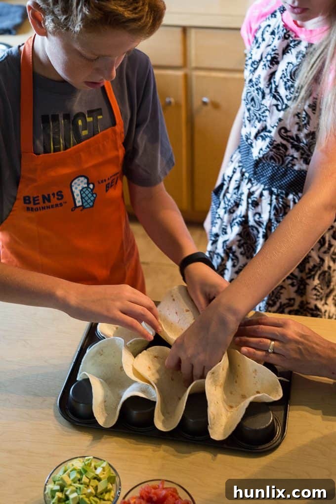 A child proudly displays a perfectly shaped tortilla taco bowl, ready for filling.