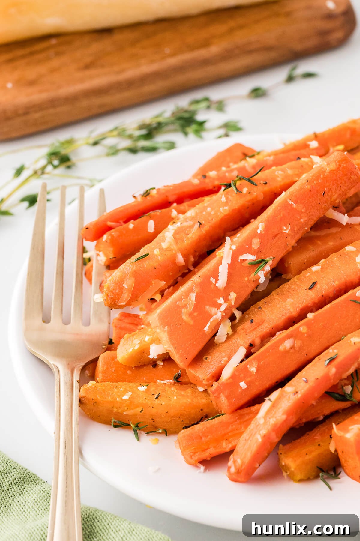 Parmesan roasted carrots on a plate with a fork.