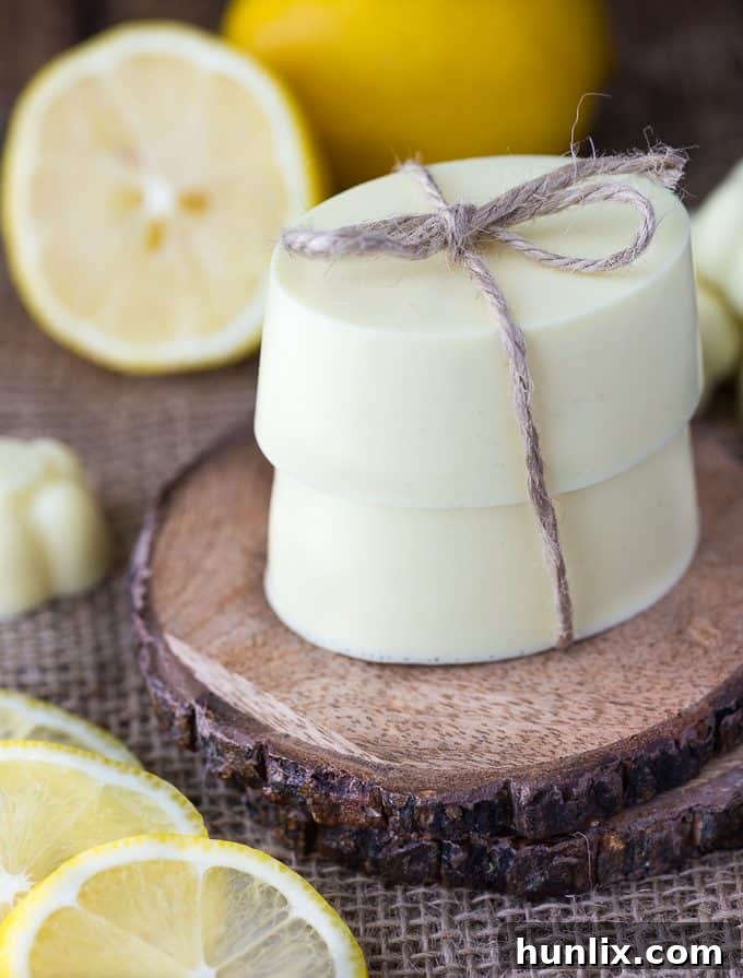 Zesty Lemon Shea Butter Bar 2 Freshly made Lemon Shea Butter Soap bars, creamy and yellow, resting on a rustic surface. This beautiful DIY soap is easy to make and perfect for sensitive skin.