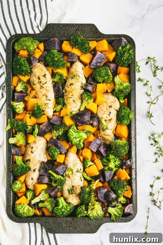 Close-up of golden-brown One-Pan Maple Dijon Chicken with vibrant roasted vegetables.