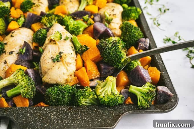 Preparing the sheet pan: raw chicken tenders laid out next to cubed butternut squash and purple potatoes, ready for seasoning.