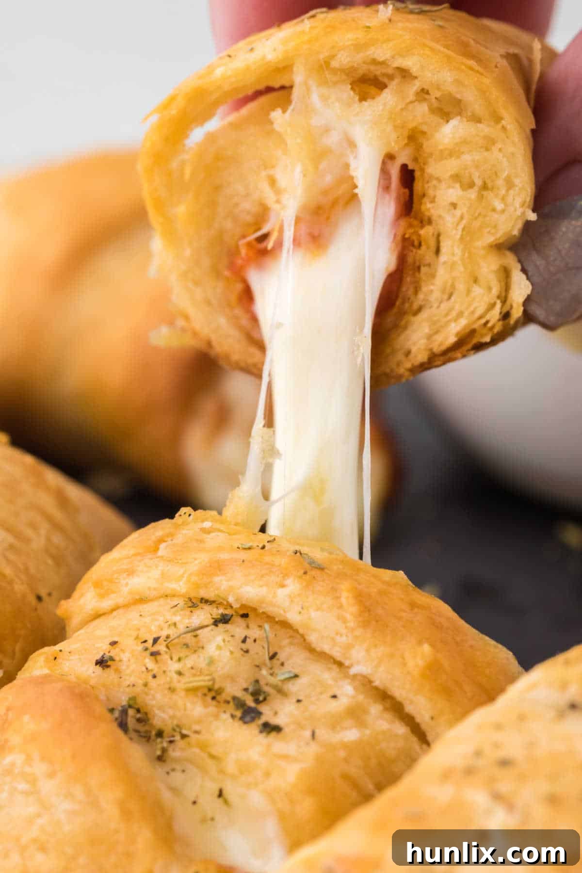 A pizza roll cut in half, revealing the perfectly melted cheese and pepperoni inside, showing the gooey texture.
