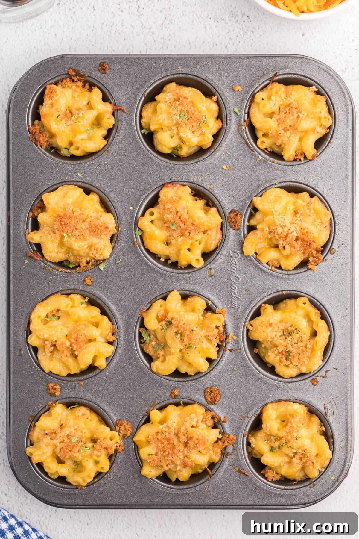 Mac and cheese cups baked in a muffin tin, ready to be served.