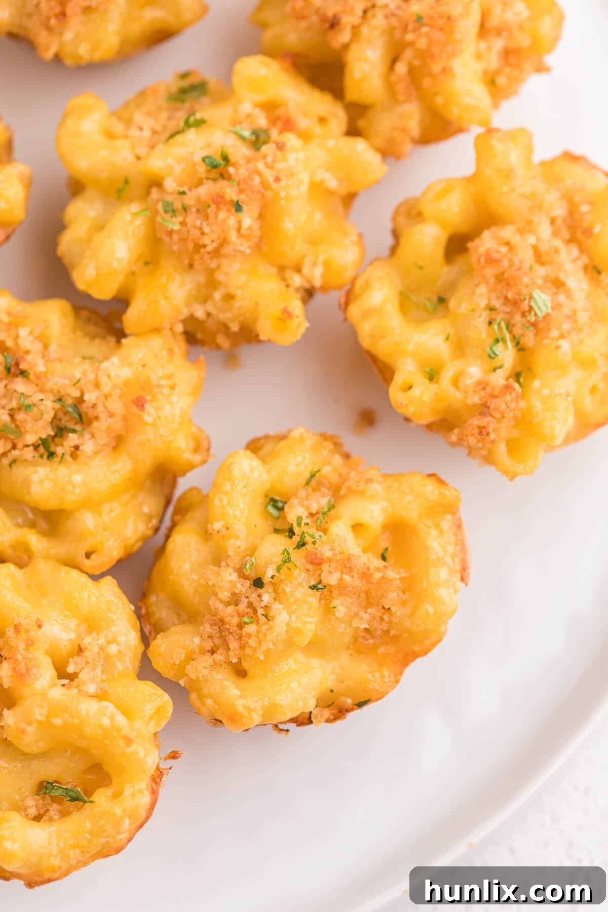 Close-up of a stack of mac and cheese cups on a plate, ready to be eaten.