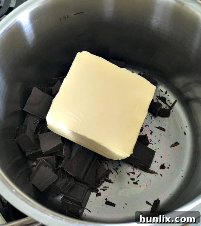 Melting butter and unsweetened baking chocolate in a saucepan over low heat for the brownie base.
