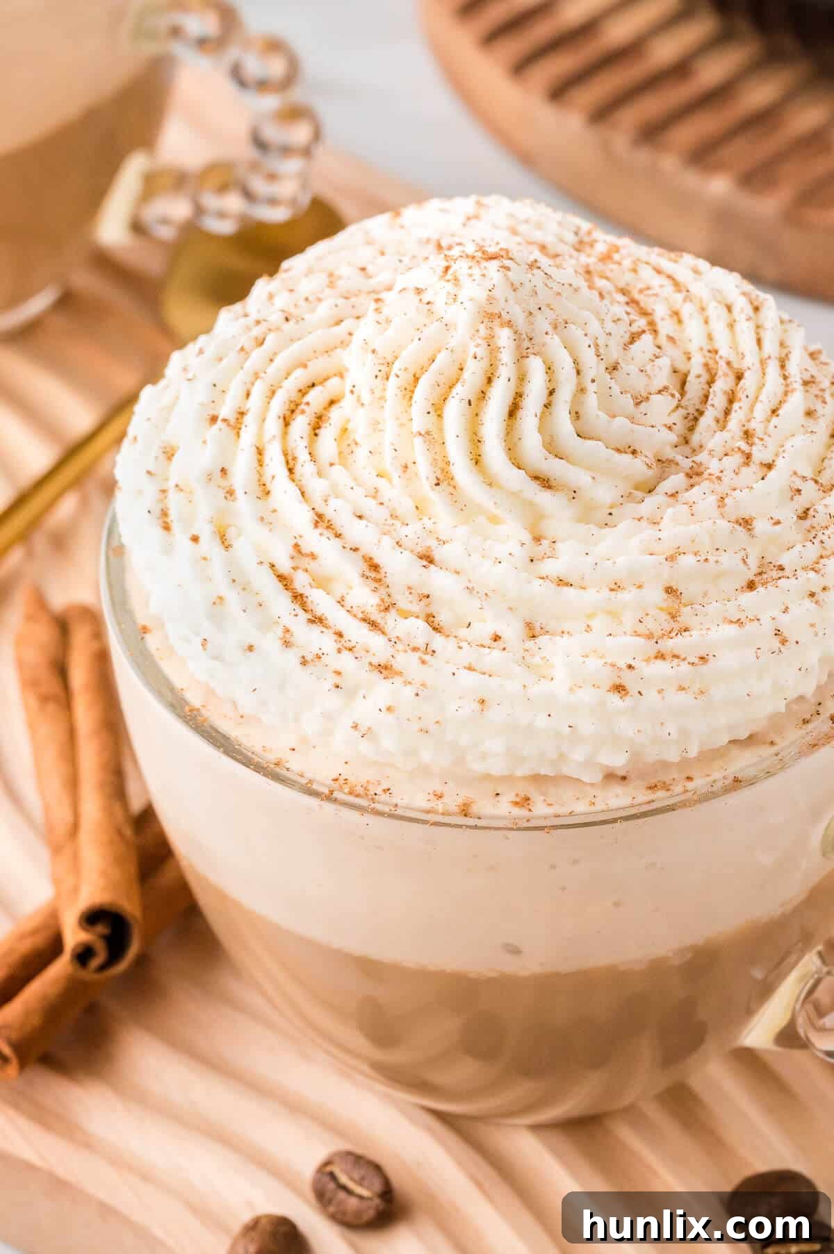 A charming mug filled with the cinnamon cappuccino, featuring a rich, dark base and a thick layer of frothy milk, ready to be enjoyed.