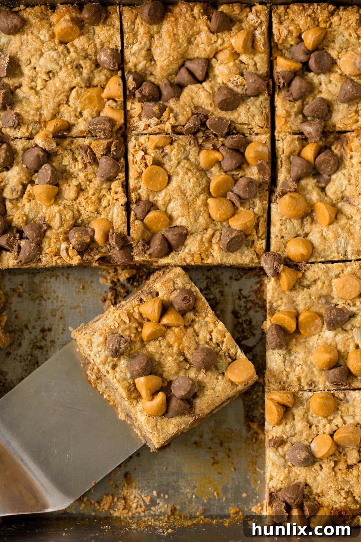 Chewy bars in the pan with a spatula, ready to be cut and served.