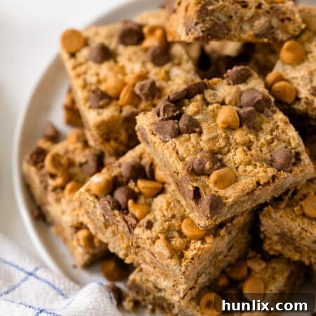A single chewy bar on a plate with a bite taken out.