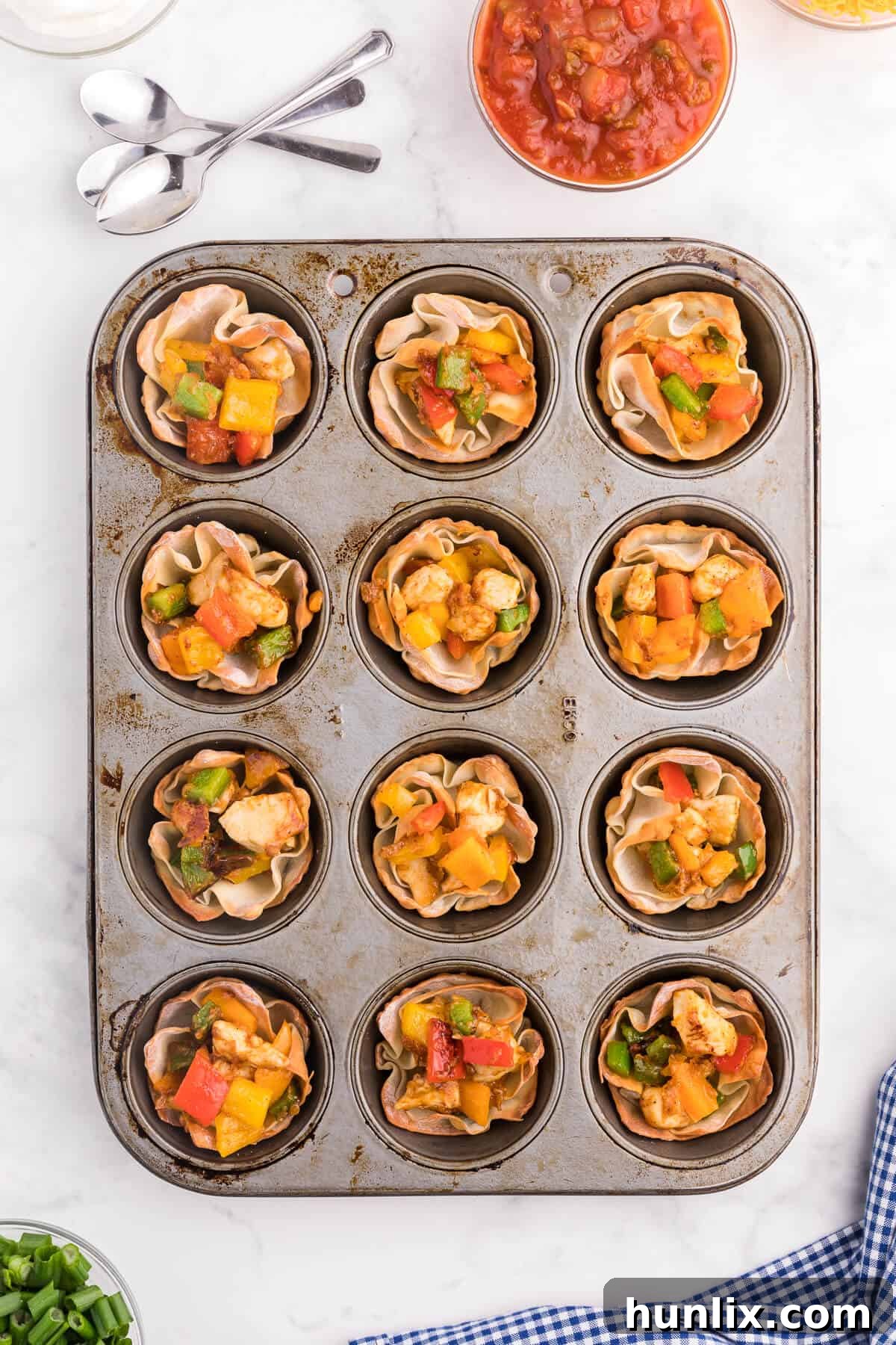 Chicken Fajita Wonton Cups - A little East, a little West. These appetizer cups are perfect for entertaining with a festive Mexican filling in a crunchy wonton.