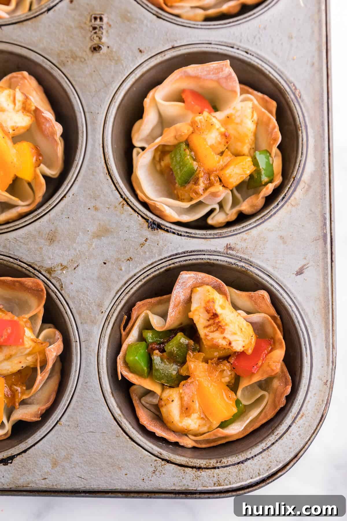 Chicken Fajita Wonton Cups - A little East, a little West. These appetizer cups are perfect for entertaining with a festive Mexican filling in a crunchy wonton.