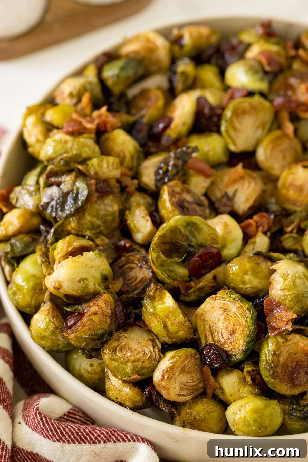 Crispy Bacon Cranberry Roasted Brussels 7 A bowl overflowing with roasted brussel sprouts, cranberries, and bacon, inviting you to try a bite.