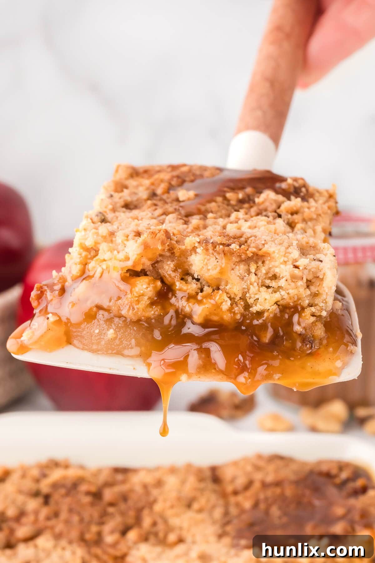 A slice of golden-brown apple dump cake resting on a spatula, ready to be served.