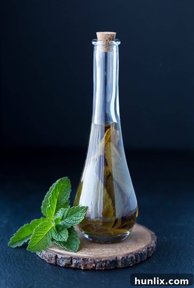Homemade Mint Extract - A close-up of a jar filled with homemade mint extract, showing the rich green tint.