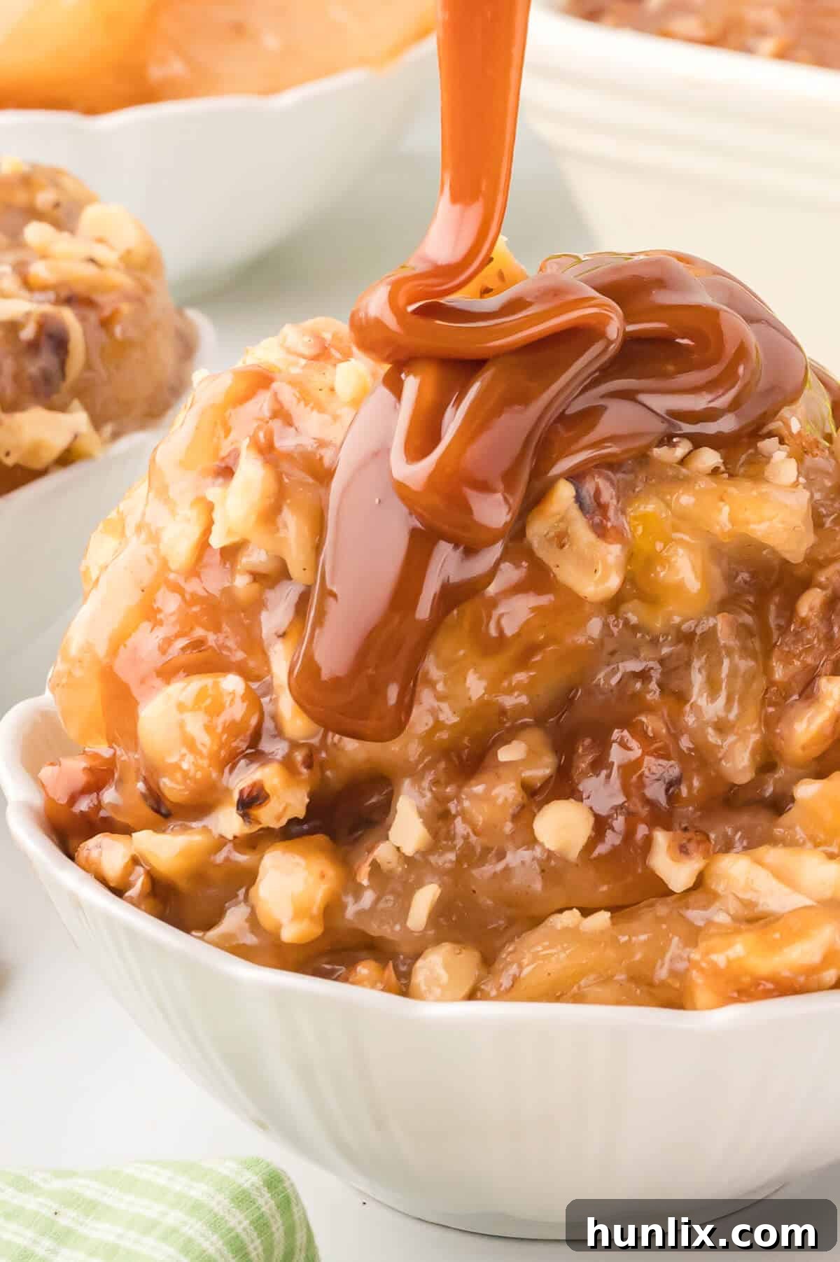 A bowl of Apple Butterscotch Buns, generously drizzled with extra caramel or butterscotch sauce.