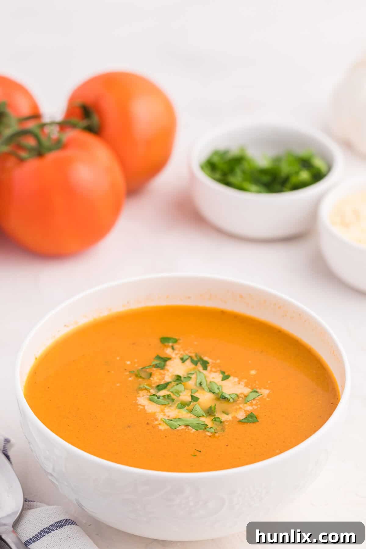 A vibrant bowl of roasted garlic and tomato soup, ready to be served.
