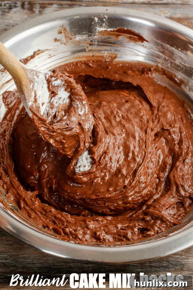 Chocolate batter in a bowl with a wooden spoon.