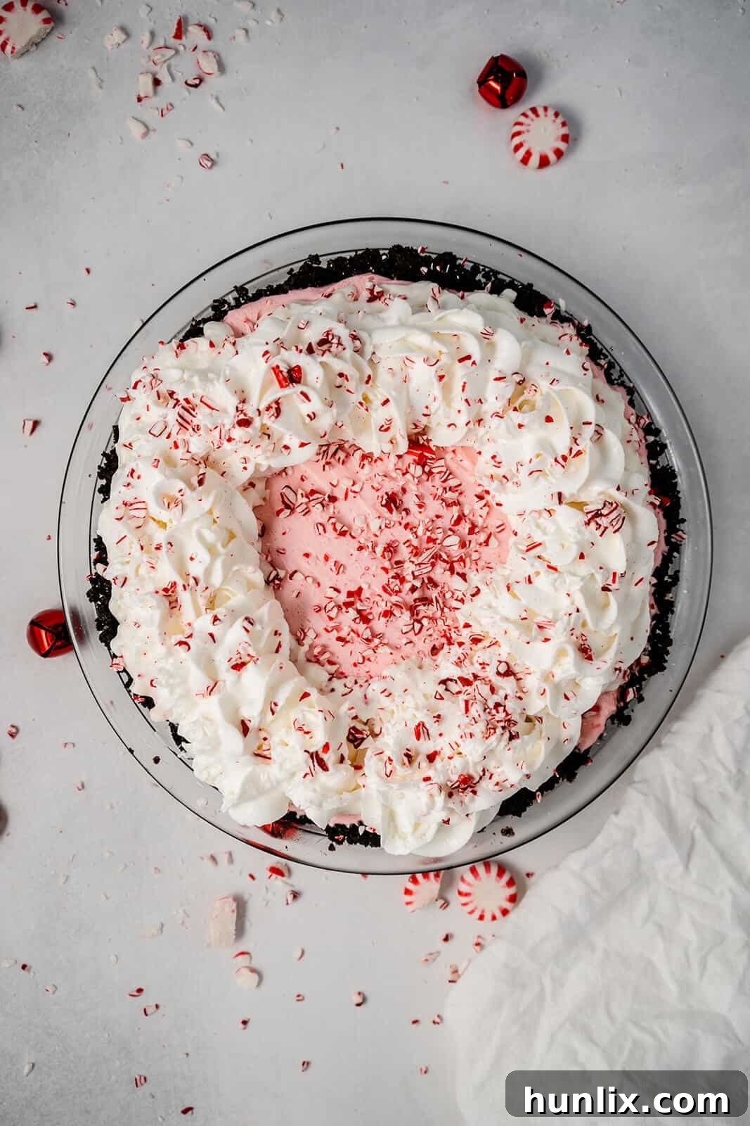 No-Bake Peppermint Pie - A top-down view of the whole pie, garnished with swirls of whipped cream and crushed peppermint.