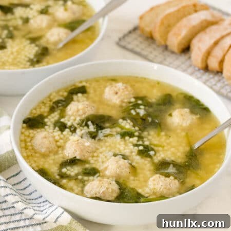 Hearty Italian Wedding Soup with Tender Chicken Meatballs 9 Italian meatball soup in a bowl with a spoon.
