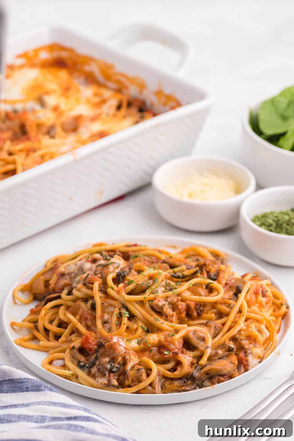 Ultimate Baked Spaghetti 6 Spaghetti bake served on a white plate, showing a perfect slice of the casserole.