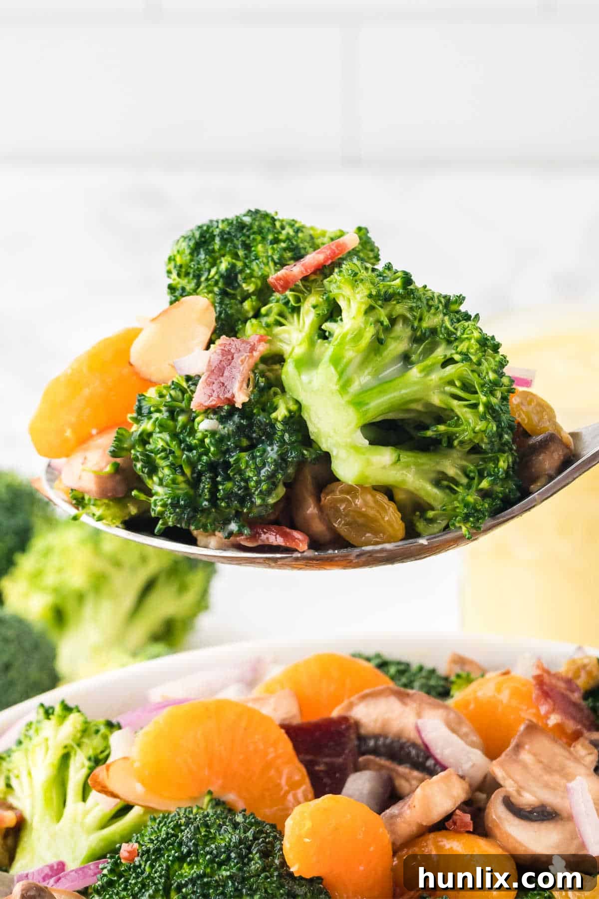 Creamy Broccoli Salad 9 Broccoli salad served on a wooden serving spoon.