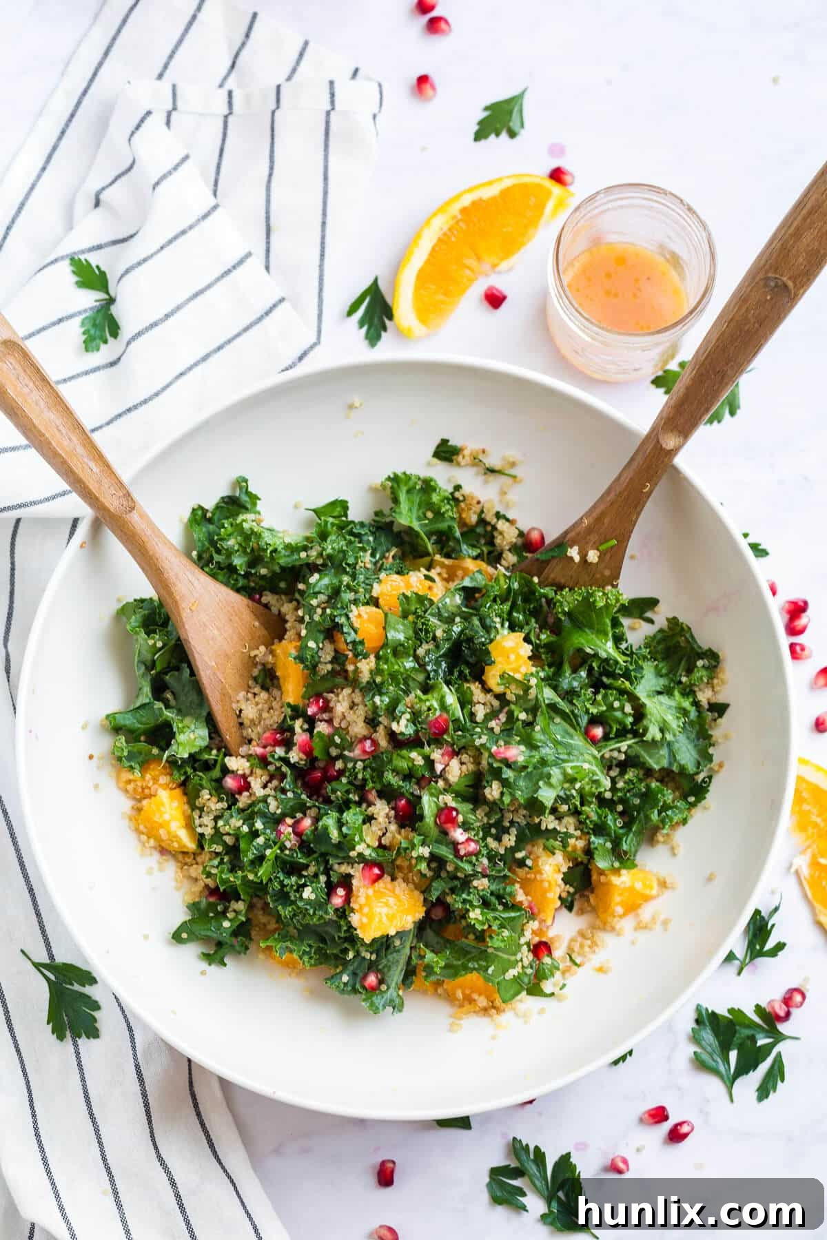 Nourishing Winter Reset Salad 6 A large bowl of winter detox salad with salad tongs, showcasing its vibrant ingredients.