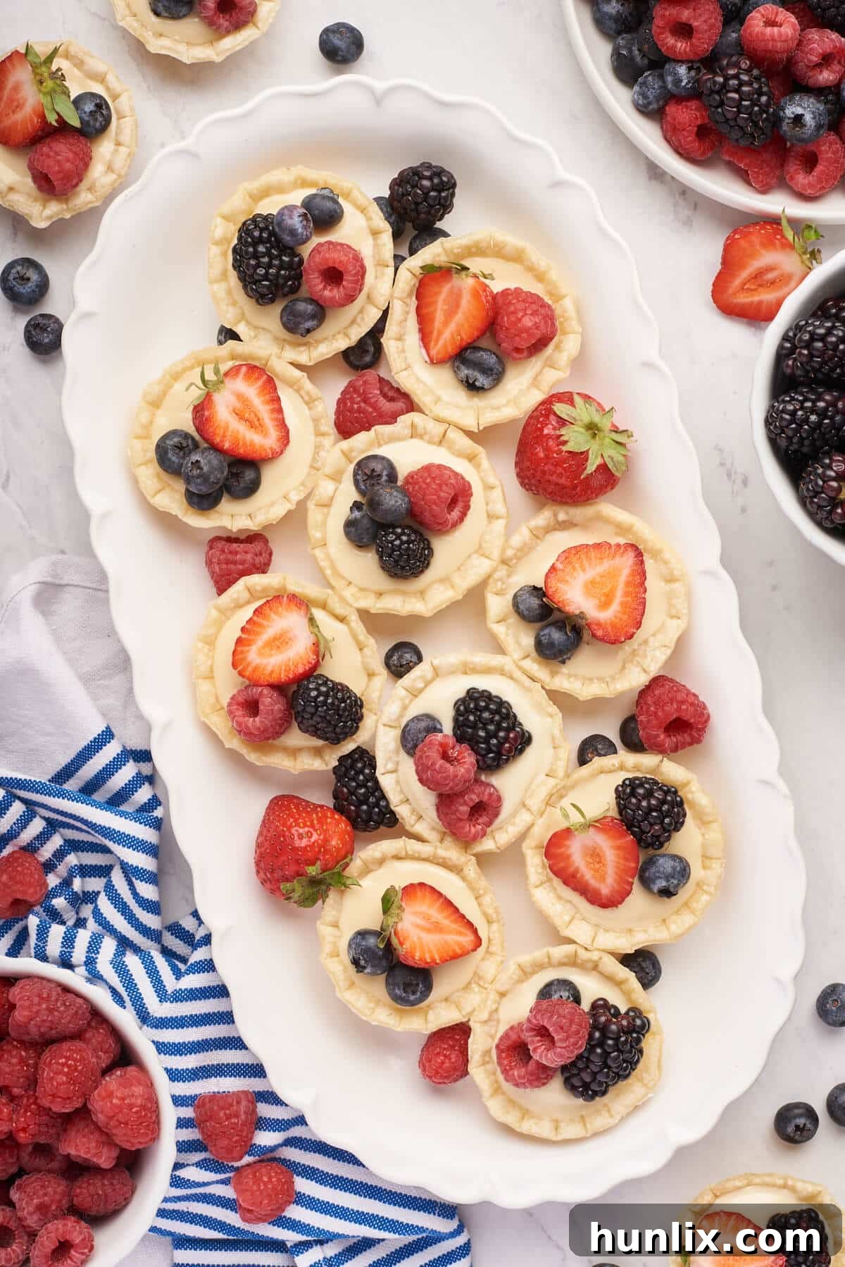 Cream cheese fruit tarts on a platter, showcasing their vibrant fruit topping.