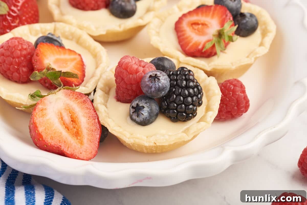 A close-up shot of cream cheese fruit tarts with mixed berries.