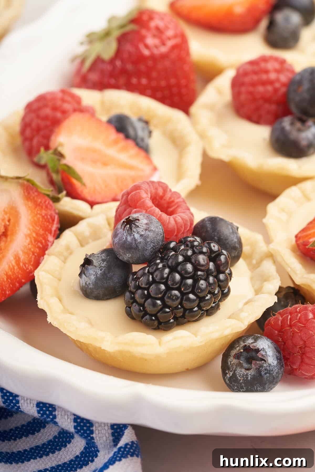 A platter of cream cheese fruit tarts, beautifully arranged and ready to be enjoyed.