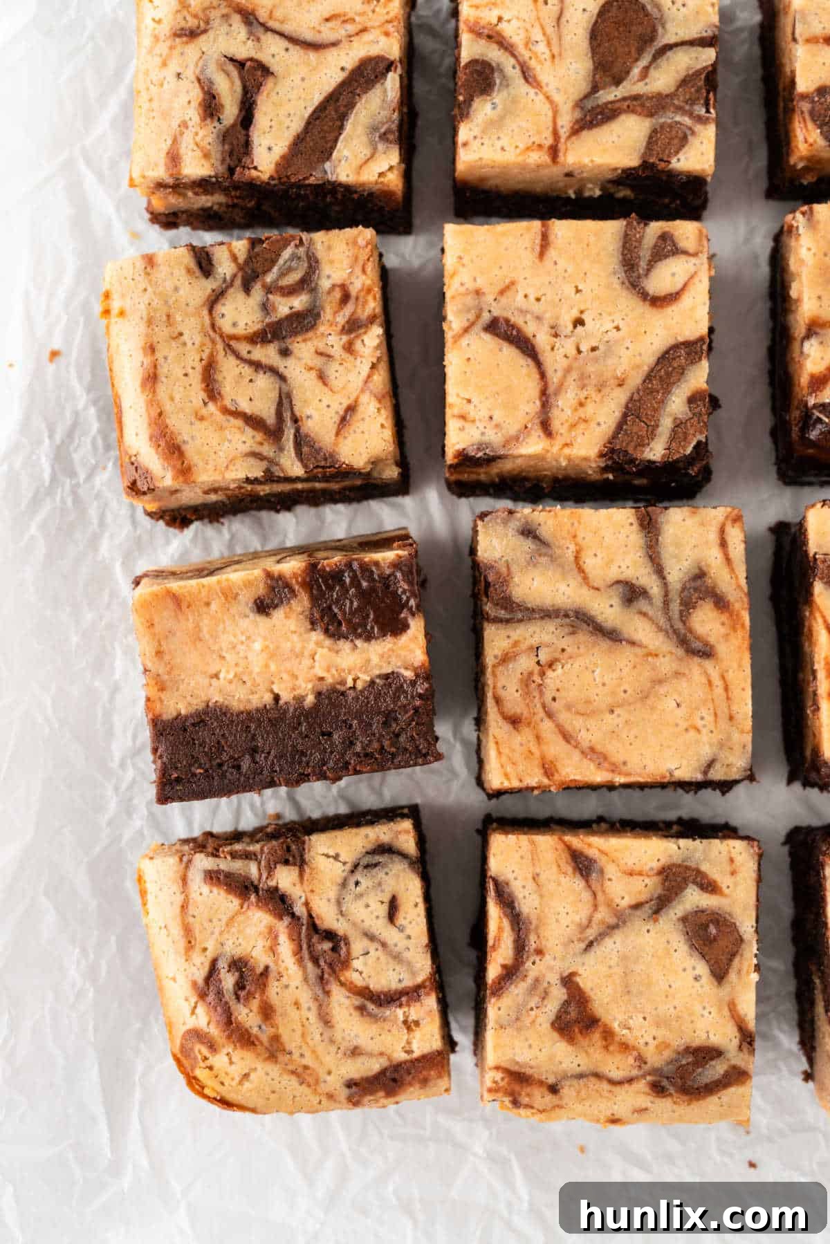 Peanut butter cheesecake brownies cut into squares, showcasing distinct layers.