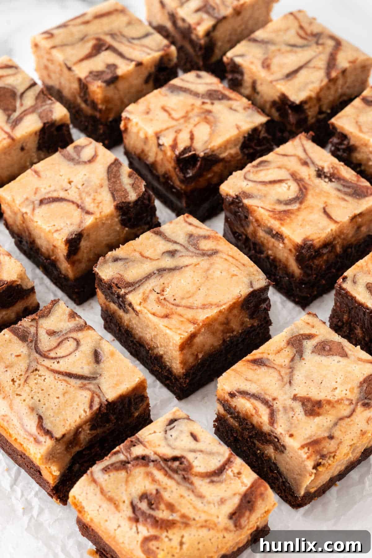 Close-up of peanut butter cheesecake brownies cut into bars, displaying the layers and swirl.
