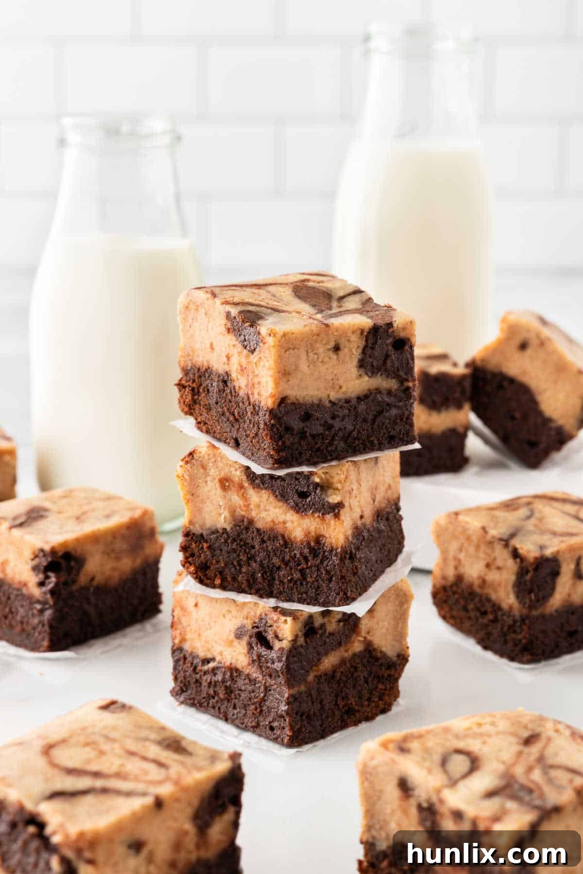 A stack of three peanut butter cheesecake brownies, showing the thick layers and swirled topping.