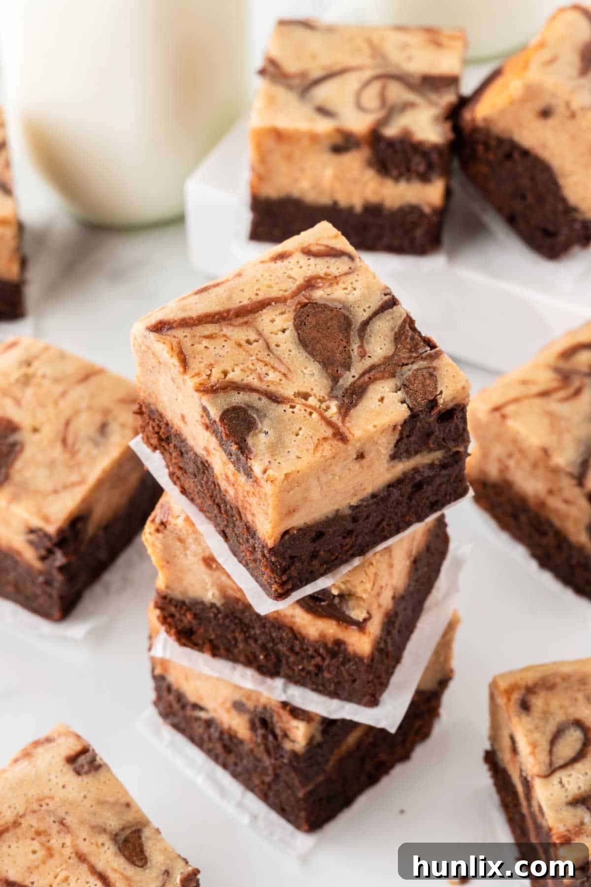A vibrant stack of peanut butter cheesecake brownies, highlighting the layers and swirl.