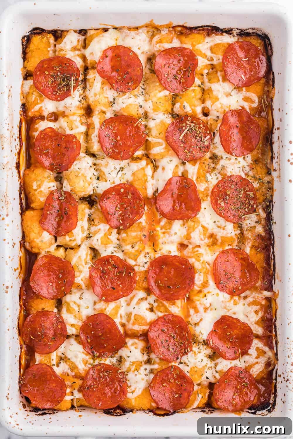 A bubbling hot Pizza Tater Tot Casserole fresh from the oven, served in a classic rectangular casserole dish, showcasing crispy tater tots and melted cheese.