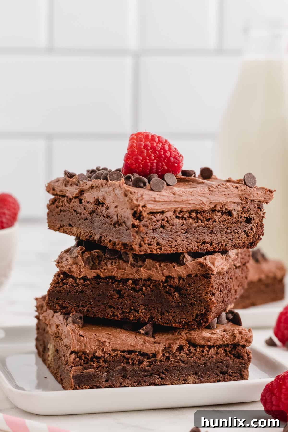 A stack of delicious chocolate raspberry brownies, showcasing their thick frosting and tempting layers.