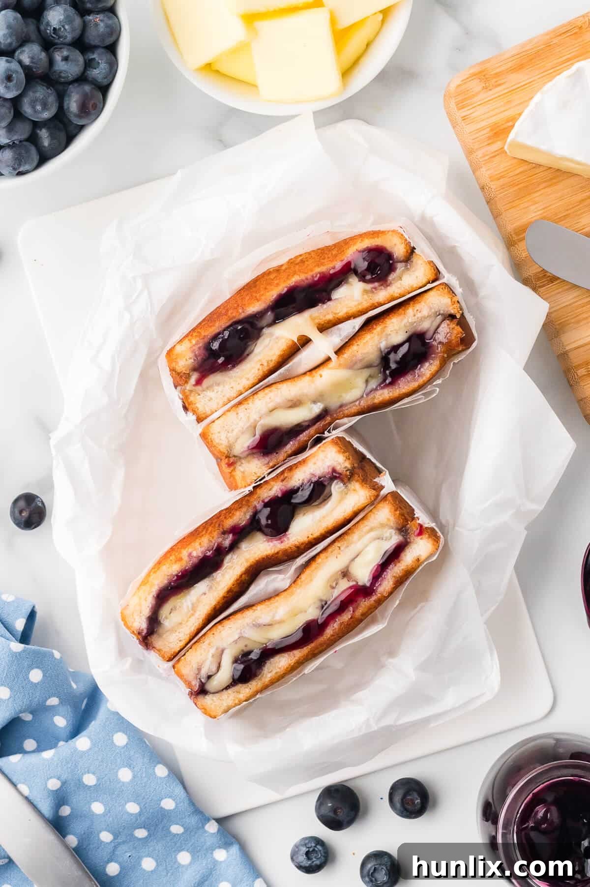 A blueberry brie grilled cheese in parchment paper, showcasing its golden crust and melted filling.