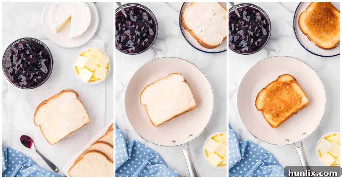 A blueberry brie grilled cheese cooking in a skillet, showing a golden-brown crust.