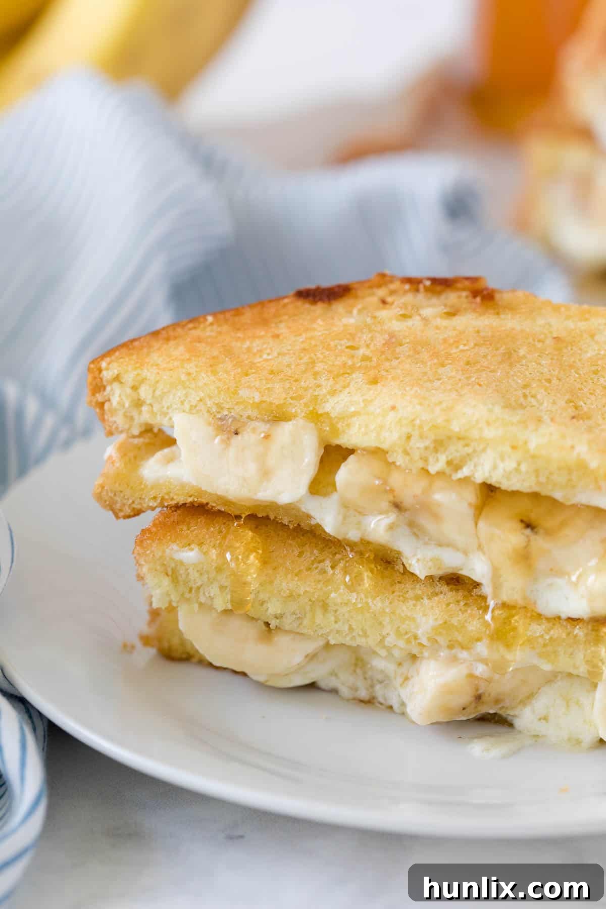 A close-up of a Honey Banana Grilled Cheese Sandwich on a plate, showing the golden-brown bread.
