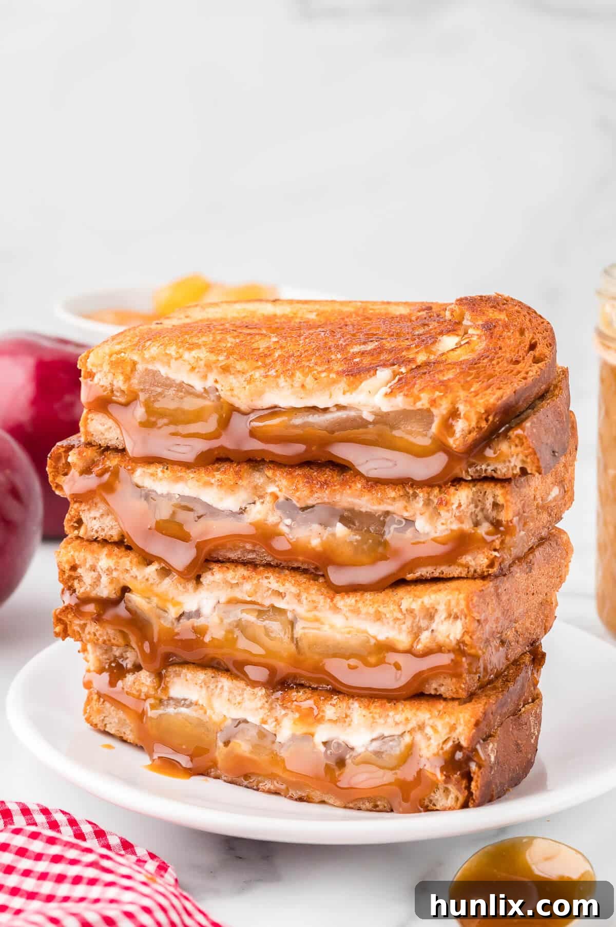 Sweet & Savory Caramel Apple Melt 2 Caramel apple grilled cheese sandwich stacked on a plate, showcasing its gooey layers and golden-brown bread.